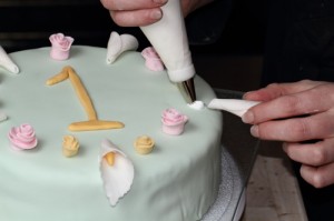 placing decorations on birthday cake with royal icing, photo by LdV