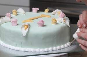 piping a decorative border with royal icing on a birthday cake, photo by LdV