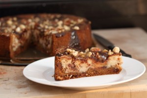 A slice of cheesecake - chocolate chip cookie crust, with chocolate, nuts and caramel filling
