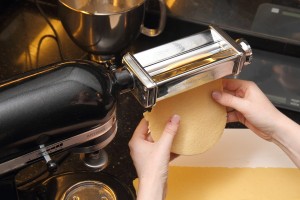 Rolling a sheet of fresh pasta.