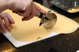 Cutting sheets of fresh pasta to roll into rigatoni.
